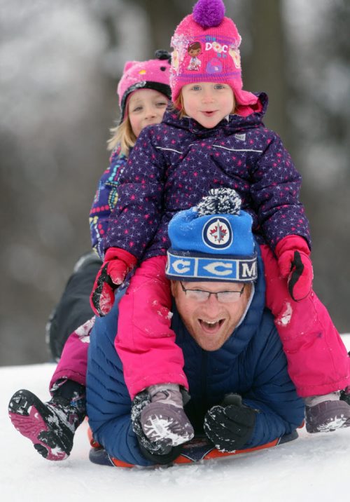 Mike Luczak, with his daughter Elise, top-front, and Julia enjoy a wonderful day Tuesday sledding at Kildonan Park during their Christmas break Standup PhotoDec 22, 2015 (JOE BRYKSA / WINNIPEG FREE PRESS)