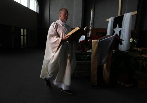 Christmas Front: Parish - St. Paul the Apostle, Father Eric Giddens  Father Giddens prepares for his Christmas message to his parishoners on making room in their lives for the new Syrian family the church is sponsoring that will arrive in early in new year. See Paul Wiecek's story Dec 22, 2015 Ruth Bonneville / Winnipeg Free Press