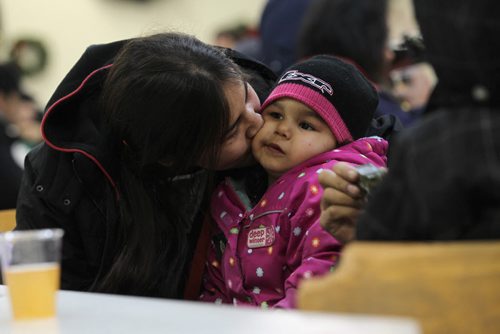 Karly Davis gives her daughter, Leah -3yrs a kiss while waiting with her family in Siloam Mission's waiting area at 303 Princess before heading in for Christmas Dinner Thursday afternoon. See story on Siloam.    Dec 24, 2015 Ruth Bonneville / Winnipeg Free Press