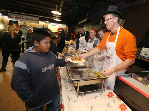 Andrew Swan, MLA for Minto (right), and other volunteers serve up food at the 10th annual Sons of Italy Christmas Eve Feast at X-Cues Billiards and Café on Dec. 24, 2015. Partners for the event included X-Cues, Sorrentos on Ellice and the West End BIZ. About 600 people were fed at the feast and 225 food hampers were distributed, as were gifts for about 250 children. Photo by Jason Halstead/Winnipeg Free Press RE: Social Page