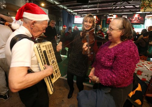 L-R: Bjarne Aasland, Daria Watkin and singer Linda Goral perform for diners at the 10th annual Sons of Italy Christmas Eve Feast at X-Cues Billiards and Café on Dec. 24, 2015. Partners for the event included X-Cues, Sorrentos on Ellice and the West End BIZ. About 600 people were fed at the feast and 225 food hampers were distributed, as were gifts for about 250 children. Photo by Jason Halstead/Winnipeg Free Press RE: Social Page