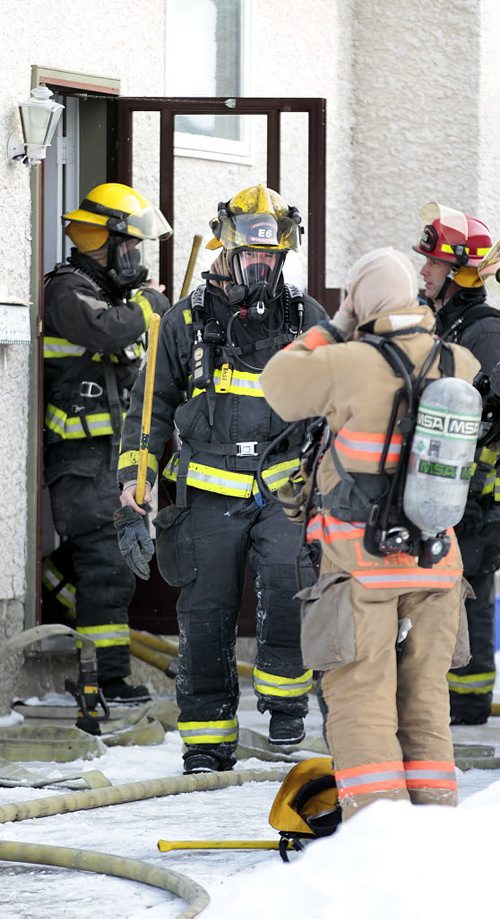 City Fire crews exit a home at 165 Tiberland Trail in the city's northern end. A faulty furnace fan was the source of the smoke filling the house, firefighters were able to prevent further damage. Eight residents of the home were examined at the scene for smoke inhalation but not transported to hospital. December 25, 2015 - (Phil Hossack / Winnipeg Free Press)