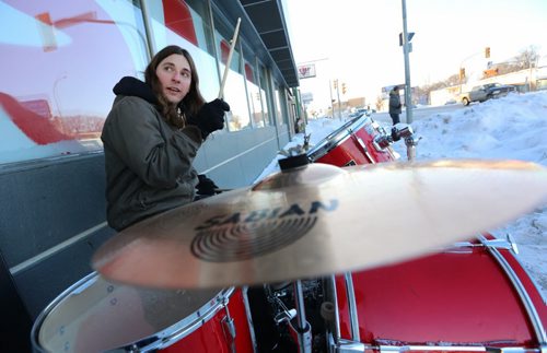 Shane Barron playing the drums on the sidewalk outside Quest Musique on Portage Avenue near Stiles Street, Saturday, December 26, 2015. (TREVOR HAGAN / WINNIPEG FREE PRESS)