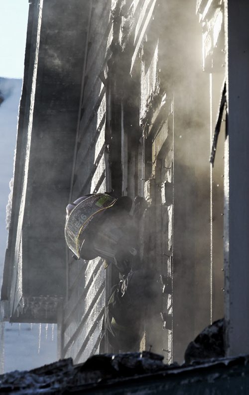 Firefighters work on putting out a fire in a house on Parr Street close to Dufferin Ave Sunday afternoon. No word on injuries or damage.  151227 December 27, 2015 MIKE DEAL / WINNIPEG FREE PRESS