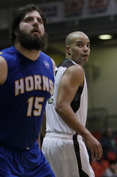 December 28, 2015 - 151228  - University of Manitoba Bisons' Keith Omoerah (2) looks on as a teammate sinks the ball for 2 against Carl Hoffman (15) and the University of Lethbridge Pronghorns in the Wesmen Classic Monday, December 28, 2015.  John Woods / Winnipeg Free Press
