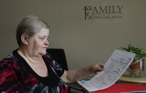 Penny Treflin, at home with her CFS adoption file she received last summer. When the provinces records were opened up earlier this year, she didnt get as much useful info as she had hoped. But a couple of weeks ago, out of the blue, her birth family found her. Larry Kusch story. Wayne Glowacki / Winnipeg Free Press Dec. 30  2015