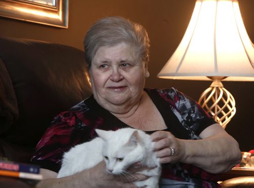 Penny Treflin, at home with her cat Gizmo. When the provinces adoption records were opened up earlier this year, she didnt get as much useful info as she had hoped. But a couple of weeks ago, out of the blue, her birth family found her. Larry Kusch story. Wayne Glowacki / Winnipeg Free Press Dec. 30  2015