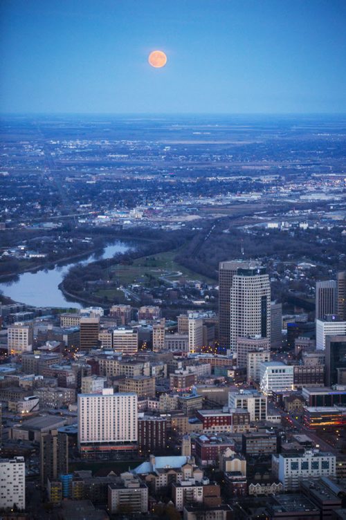 The moon rises over downtown Winnipeg, as seen from the air, on Monday, Oct. 26, 2015.  (Mikaela MacKenzie/Winnipeg Free Press)