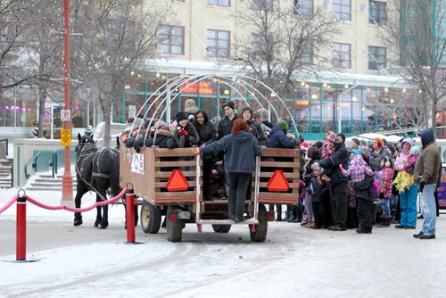 People line-up at the Forks for their turn to ride in the  Horse-drawn Hay-Ride as it makes its way around the Forks grounds as part of the family fun activities taking place at the Forks Thursday for  New Years Eve. Standup   Dec 31, 2015 Ruth Bonneville / Winnipeg Free Press