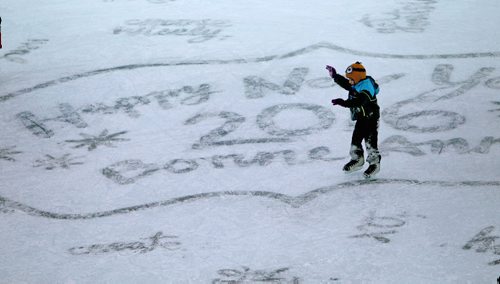 A child raises their arms to keep their balance as they skate under the canopy on the ice at the Forks Thursday hat has "Happy New Year 2016" written in the ice for New Years Eve celebrations.  Standup   Dec 31, 2015 Ruth Bonneville / Winnipeg Free Press