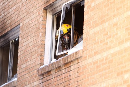 A member of the Fire Dept. looks out the window from the 2nd storey of and apartment at 188 Colony Street Friday afternoon after a mother jumped out with her baby when a fire broke out in the suite.  Both the child and mother were treated on the scene. No further information at this time except that bystanders said they didn't see any serious injuries.   Jan 01, 2016 Ruth Bonneville / Winnipeg Free Press