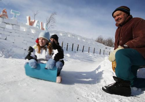 John Woods / Winnipeg Free Press / February 2, 2008- 080202  - Ray Schwartz watches his grandchildren Brett (L) and Katee Weremiuk as the slide down a toboggan run that he made beside his great wall of snow in his back yard Saturday, February 2/08.
