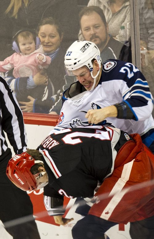 DAVID LIPNOWSKI / WINNIPEG FREE PRESS 160103  An infant points and laughs as Manitoba Moose Darren Kramer (#22) fights Grand Rapids Griffins Louis-Marc Aubry (#22) Sunday January 3, 2016 at MTS Centre.