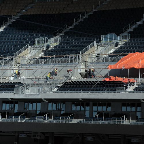 Workers with jackhamers and shovels remove concrete from the second level of the seating area at Investor's Group Field Monday. See story. January 4, 2015 - (Phil Hossack / Winniperg Free Press)