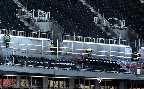 Workers with jackhamers and shovels remove concrete from the second level of the seating area at Investor's Group Field Monday. See story. January 4, 2015 - (Phil Hossack / Winniperg Free Press)