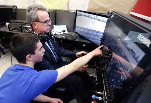 Education Minister James Allum gets some flight simulator training from Carter Trudel, a grade 11 Sturgeon Heights Collegiate student Tuesday after the provincial government's annual announcement of operating grants for the public school system.  The Manitoba government will be increasing the provinces share of the $2.25-billion public education system by $32.5 million  or 2.55 per cent. The event was held in the aviation classroom in Sturgeon Heights Collegiate.  Nick Martin story Wayne Glowacki / Winnipeg Free Press Jan. 5 2016