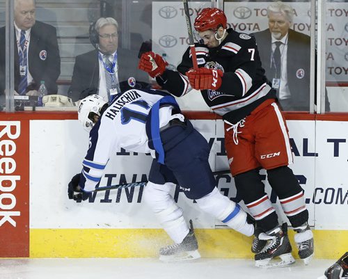 Manitoba Moose Matt Halischuk (15) gets checked by Grand Rapids Griffins' Ryan Sproul (7) during first period AHL action in Winnipeg on Tuesday, January 5, 2016. (John Woods / WINNIPEG FREE PRESS)