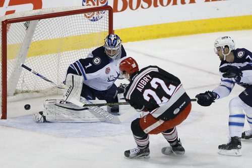 Manitoba Moose goaltender Eric Comrie (1) saves the shot from Grand Rapids Griffins' Louis-Marc Aubry (22) as Josh Morrissey (7) defends during first period AHL action in Winnipeg on Tuesday, January 5, 2016. (John Woods / WINNIPEG FREE PRESS)
