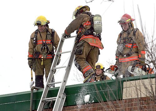BORIS MINKEVICH / WINNIPEG FREE PRESS  080203 Fire crews work on the roof at a St. Mary's Road address near St. Anne's road. A fire broke out there in the back of the building.