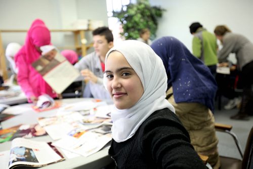 Syrian youths who arrived with their families within the last few days to Winnipeg cut photos out of magazines that represent their future dreams at a class at NEEDS,  a  pre-education program to help students get acclimatized and prepared to enter the public school  system when they get into their permanent housing.  Girl in front - Eilaf Khaled (white head scarf).  See Carol Sanders story.     Jan 06, 2016 Ruth Bonneville / Winnipeg Free Press