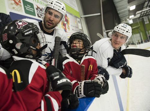 DAVID LIPNOWSKI / WINNIPEG FREE PRESS 160106  Manitoba Moose #28 Patrice Cormier (left) and #42 Peter Stoykewych (right) give some tips to 9-year-old Red Seals #18 Javon Havelka and #12 Nevin Abraham during a community practice on Wednesday January 6 at the Southdale Community Centre.