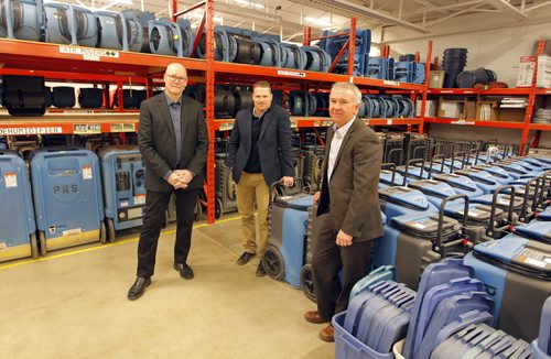 BIZ- Priority Restoration. left-right: VP Finance Richard Hutchings, VP general manager Scott Meyer,, and managing partner/president Ken Klassen pose for a photo in the warehouse where they store some restoration equipment used in the business. BORIS MINKEVICH / WINNIPEG FREE PRESS  January 7, 2016