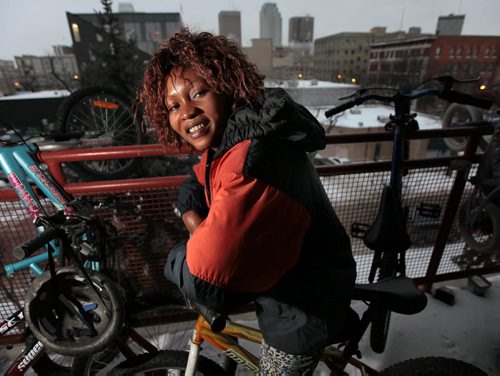 Musu Kayfay and her family ( two kids, a sister and sister-in-law) who arrived in March from Sierra Leone for Year of the Refugee 49.8. Winter was her biggest surprise, now she poses on her balcony with her son's bicycle. See Carol Sanders story. January 7, 2016 - (Phil Hossack - Winnipeg Free Press)
