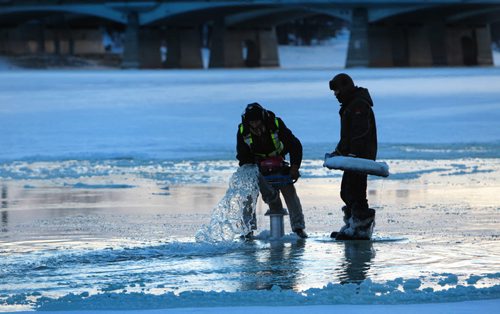 Forks River Trail construction workers pump water from the river onto the surface of the ice on the Red River Friday as crews work to create a smooth skating surface at the Forks.   Jan 08, 2016 Ruth Bonneville / Winnipeg Free Press