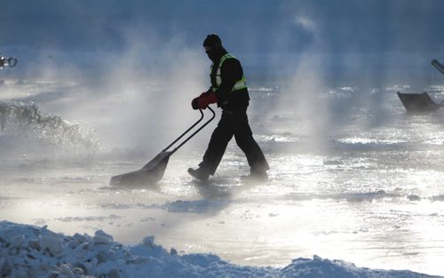 The Forks River Trail construction workers prepare  the surface of the ice on the Assiniboine River in the morning light  as crews work to create a smooth skating surface at the Forks Saturday.   Standup  Jan 09, 2016 Ruth Bonneville / Winnipeg Free Press