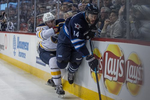 Winnipeg Jets' Anthony Peluso (14) just makes it past being checked by Buffalo Sabres' Rasmus Ristolainen (55) during second period NHL action in Winnipeg on Sunday, January 10, 2016. 160110 - Sunday, January 10, 2016 -  MIKE DEAL / WINNIPEG FREE PRESS