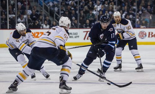 Winnipeg Jets' Adam Lowry (17) is stick checked by Buffalo Sabres' Evander Kane (9) while he tries to get past Buffalo Sabres' Rasmus Ristolainen (55) during second period NHL action in Winnipeg on Sunday, January 10, 2016. 160110 - Sunday, January 10, 2016 -  MIKE DEAL / WINNIPEG FREE PRESS