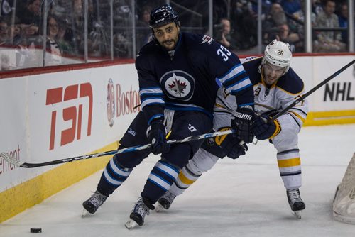 Winnipeg Jets' Dustin Byfuglien (33) behind the Buffalo Sabres net while Buffalo Sabres' Zemgus Girgensons (28) tries to catch up during second period NHL action in Winnipeg on Sunday, January 10, 2016. 160110 - Sunday, January 10, 2016 -  MIKE DEAL / WINNIPEG FREE PRESS