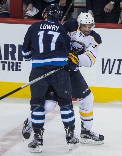 Winnipeg Jets'  Adam Lowry (17) puts the shoulder on Buffalo Sabres' Evander Kane (9) during third period NHL action in Winnipeg on Sunday, January 10, 2016. 160110 - Sunday, January 10, 2016 -  MIKE DEAL / WINNIPEG FREE PRESS
