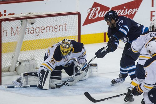 Winnipeg Jets' Dustin Byfuglien (33) tries to get the puck past Buffalo Sabres' goaltender Linus Ullmark (35) during third period NHL action in Winnipeg on Sunday, January 10, 2016. 160110 - Sunday, January 10, 2016 -  MIKE DEAL / WINNIPEG FREE PRESS