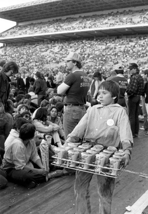 Young concession seller Jeff Swan walks by the crowds during the David Bowie concert at Winnipeg Stadium on September 14, 1983. Glenn Olsen / Winnipeg Free Press