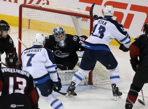 Manitoba Moose Nic Petan (13) hits the post as he tries to knock the puck past Lake Erie Monsters' goaltender Brad Thiessen during first period AHL action, Wednesday, January 13, 2016. (TREVOR HAGAN/WINNIPEG FREE PRESS)