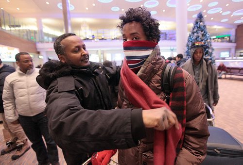 Nasiimo Ismail looks a little skeptical as he's wrapped in a scarf for Winnipeg's -20C temps Thursday. He and his siblings arrived at James RIchardson Airport Thursday to meet their brother Fathi who walked across the US/Canadian border in 2014. See Carol Sanders story. January 14, 2016 - (Phil Hossack / Winnipeg Free Press)