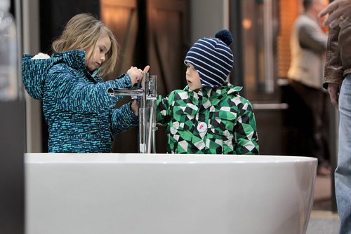 Three-year-old Luke Chapko and his sister, Ellie - 5yrs, check out the interesting faucet on a  a large soaker tub at the GreenSlade booth at the Winnipeg Renovation Show Friday afternoon with their grandfather.  The show runs throughout the weekend at RBC Convention Centre.   Standup Jan 15, 2016 Ruth Bonneville / Winnipeg Free Press