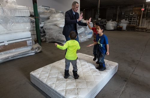 Manitoba Jobs and Economy Minister, Kevin Chief, jumps on an old mattress with some kids that were at the announcement that Mother Earth Recycling has partnered with IKEA to offer an affordable mattress recycling program on Sunday at the new Mother Earth Recycling location at 771 Main Street. If you buy and have your mattress delivered from IKEA you can have the old mattress taken away and recycled for only $10. 160117 - Sunday, January 17, 2016 -  MIKE DEAL / WINNIPEG FREE PRESS