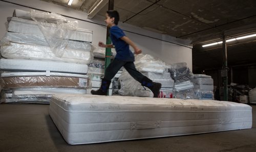Tristan McNabb, 9, jumps on an old mattress during the announcement that Mother Earth Recycling has partnered with IKEA to offer an affordable mattress recycling program on Sunday at the new Mother Earth Recycling location at 771 Main Street. If you buy and have your mattress delivered from IKEA you can have the old mattress taken away and recycled for only $10. 160117 - Sunday, January 17, 2016 -  MIKE DEAL / WINNIPEG FREE PRESS