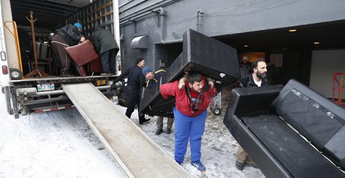 Syrian refugee volunteers and members of the Winnipeg Police Service at the Antares Luxury Suites ( formerly Place Louis Riel)  Tuesday morning move out furniture that is being donated for Syrian refugee families in Winnipeg. The donations that include leather couches and fine furnishings are being loaded onto trucks driven by Hutterite Colonies and taken to a secret location to be sorted and distributed. Bill Redekop/Carol Sanders Wayne Glowacki / Winnipeg Free Press Jan. 19 2016