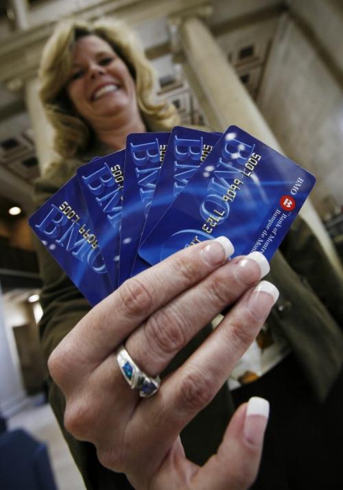 John Woods / Winnipeg Free Press / February 8, 2008- 080208  - Yvonne Couvier, Bank of Montreal Main/Portage branch manager , poses for a photograph with some bank cards Friday, February 8, 2008.  The cards will be phased out in the near future.