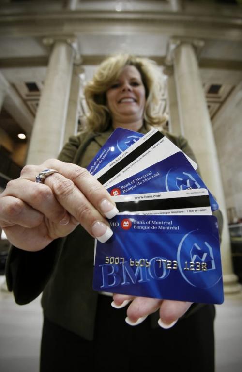 John Woods / Winnipeg Free Press / February 8, 2008- 080208  - Yvonne Couvier, Bank of Montreal Main/Portage branch manager , poses for a photograph with some bank cards Friday, February 8, 2008.  The cards will be phased out in the near future.