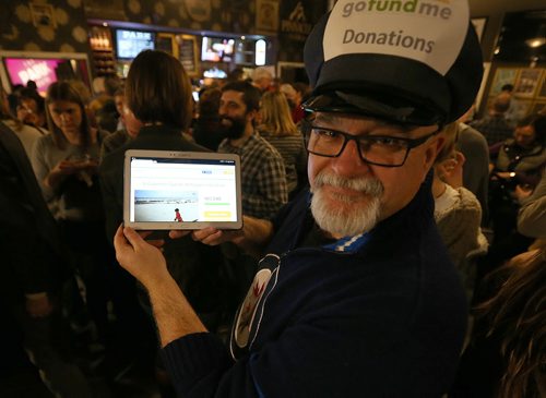 Ian Mattey, fundraising co-chairman of the South Osborne Syrian Refugee Initiative, shows off an overall tally of what the group has raised to date during a fundraising concert at the Park Theatre on Jan. 19, 2016. The event raised about $14,500 to bring Syrian families to Winnipeg and help them get settled. The concert at the Park Theatre featured local acts the Bonaduces, Sweet Alibi and DJ Co-op. Photo by Jason Halstead/Winnipeg Free Press RE: Social Page