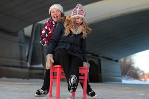 Lehla Demasson (multi-colored jacket), and her friend of many years, Brianna Seewald (dark blue) have fun as they push each other on a chair with skis under the Queen Elizabeth bridge on the newly open River Trail Thursday afternoon.   Jan 21, 2016 Ruth Bonneville / Winnipeg Free Press