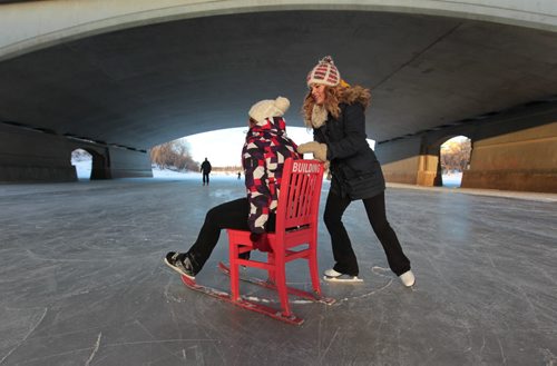 Lehla Demasson (multi-colored jacket), and her friend of many years, Brianna Seewald (dark blue) have fun as they push each other on a chair with skis under the Queen Elizabeth bridge on the newly open River Trail Thursday afternoon.   Jan 21, 2016 Ruth Bonneville / Winnipeg Free Press
