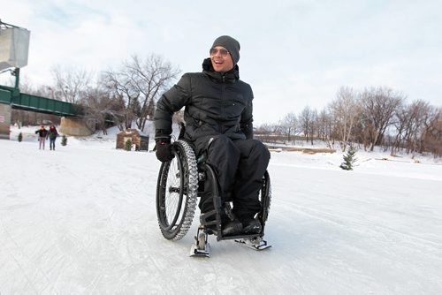 Art Monforte tries out his specialty suited skis on the base of his wheelchair on the ice as he wheels himself on the newly open River Trail Thursday afternoon which was the first time he has ever been out on a frozen river.   Jan 21, 2016 Ruth Bonneville / Winnipeg Free Press