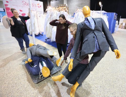 Lauren Ridd, Christine Zakaluk, and Brett Kuchciak from Eph Apparel moving mannequins across the Winnipeg Wedding Show at the Winnipeg Convention Centre, Friday, January 22, 2016. (TREVOR HAGAN / WINNIPEG FREE PRESS)