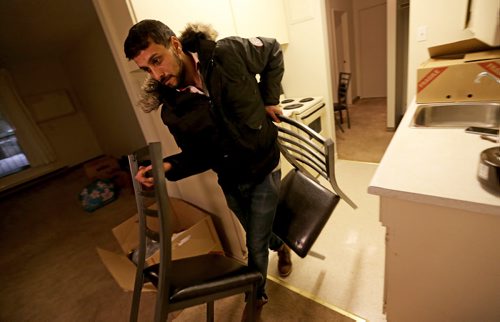 Ahmed Mohmoud, a Syrian refugee, unloading furniture with the help of Nadia Ourrhi and Abdul Absuleh, from Welcome Place, Friday, January 22, 2016. (TREVOR HAGAN/WINNIPEG FREE PRESS)