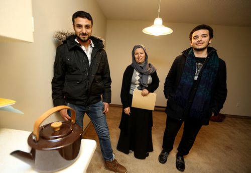 Left to right, Ahmed Mohmoud, a Syrian refugee, unloading furniture with the help of Nadia Ourrhi and Abdul Absuleh, from Welcome Place, Friday, January 22, 2016. (TREVOR HAGAN/WINNIPEG FREE PRESS)